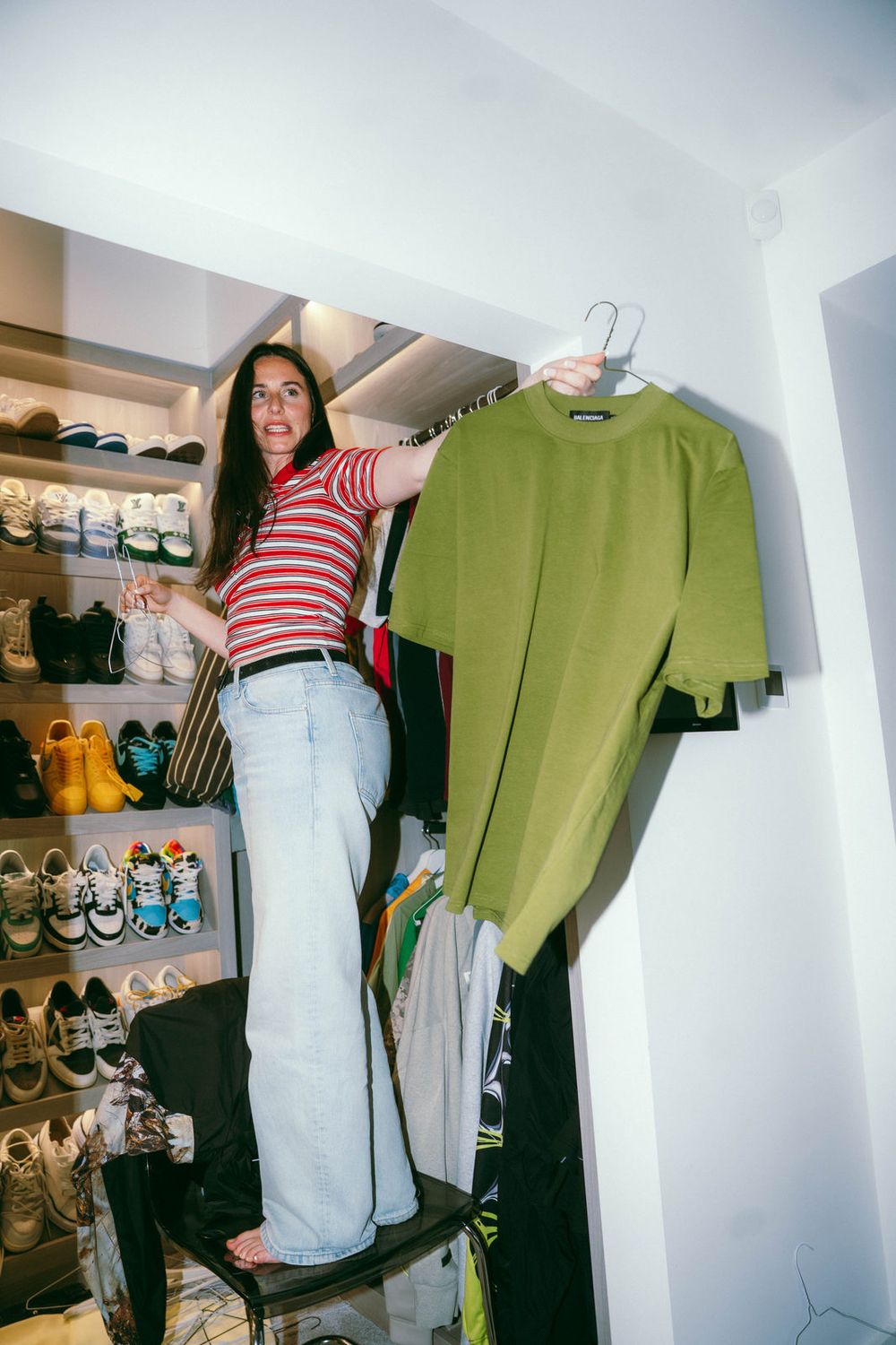 Linne Dierckx in a player's closet, holding up a piece